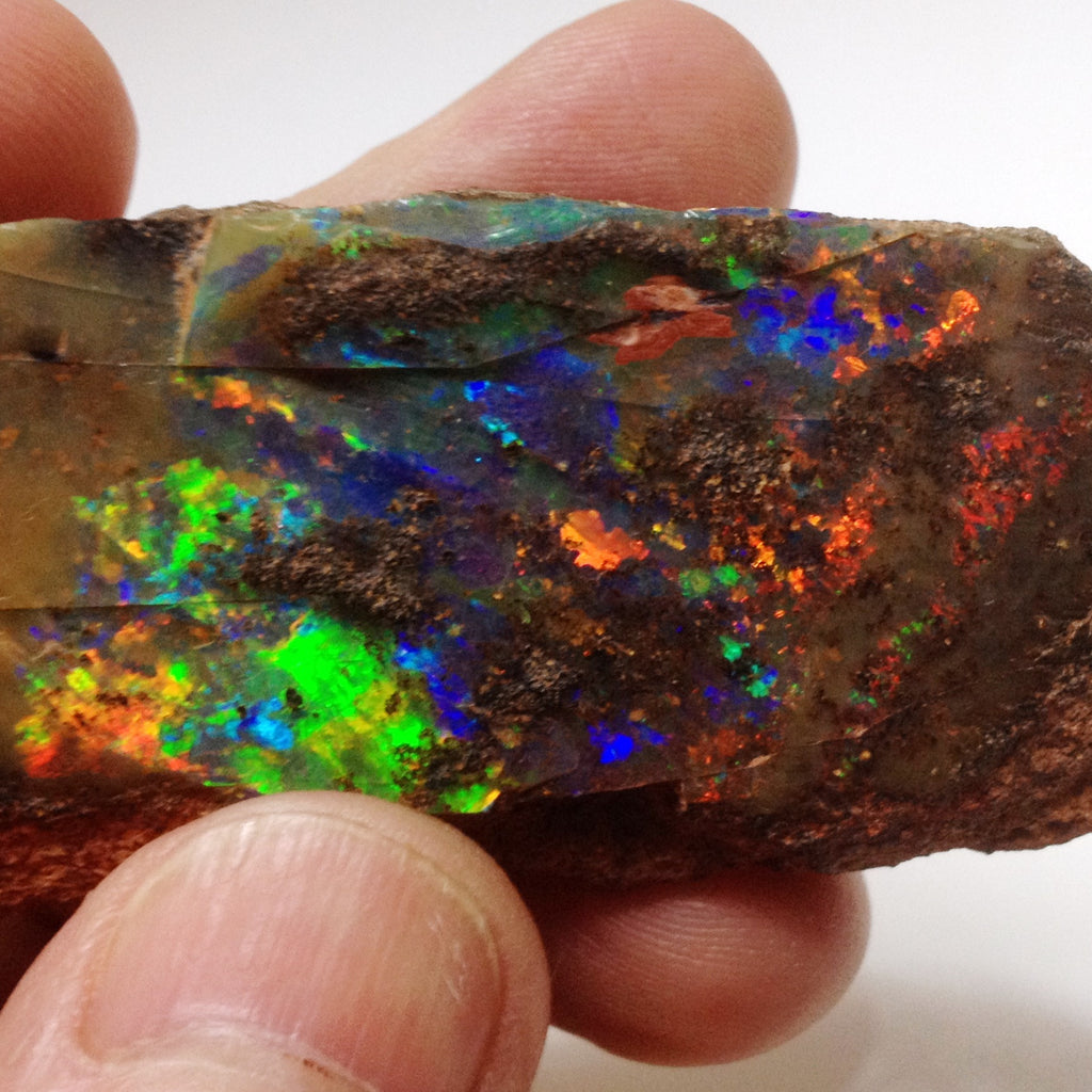 Bright red, orange, gold, green and violet Rough boulder opal