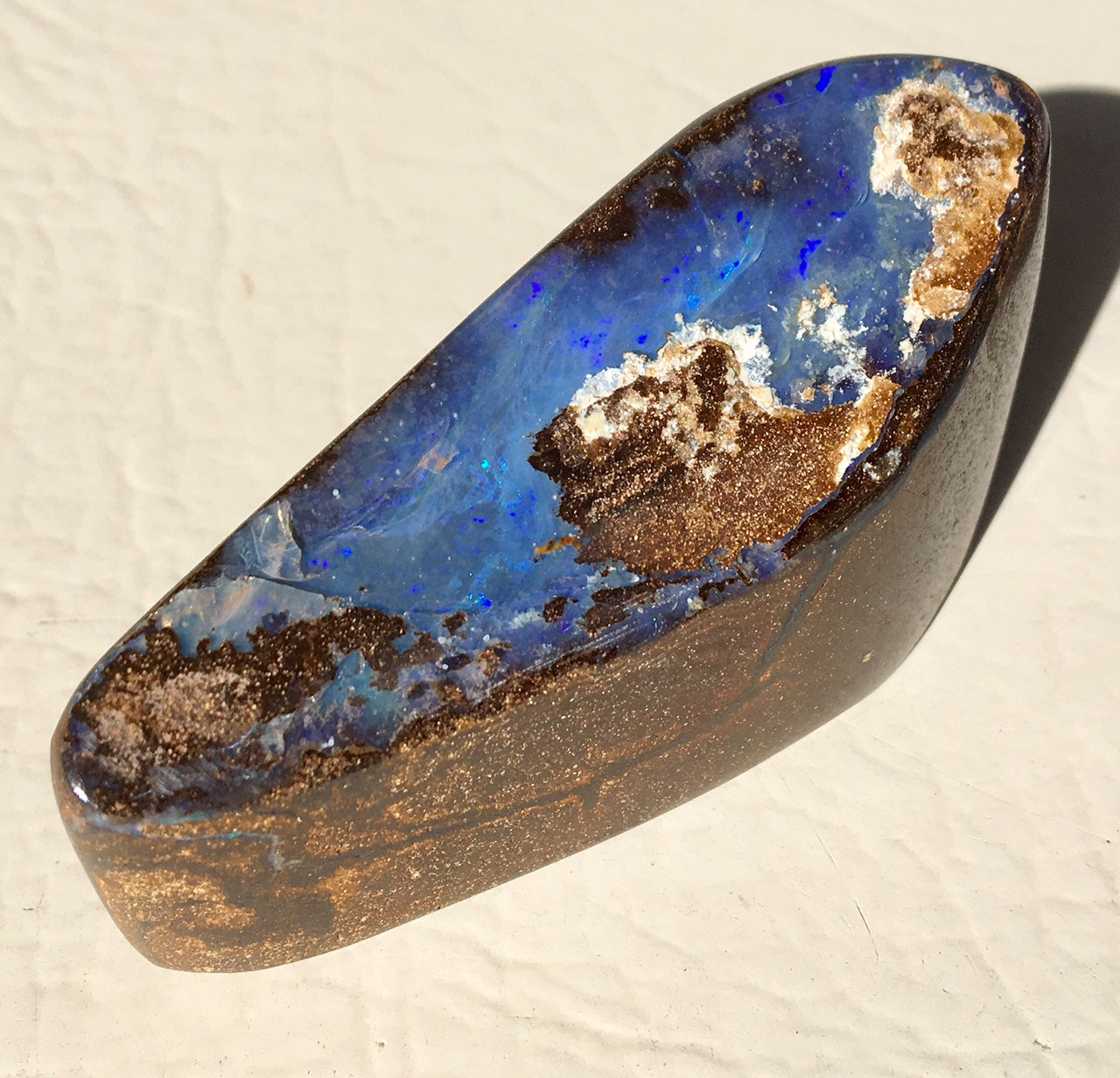Violet boulder opal polished speciman