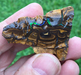 Rough boulder opal with bright green bars